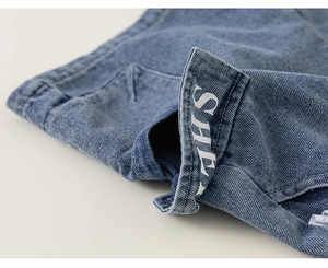 Detailed macro view of denim fabric texture with white letter printing and neat stitching