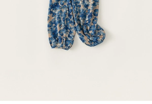 Détail d'un pantalon décontracté pour enfant avec motifs floraux et ourlet élastique