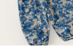 Détail du poignet élastique sur pantalon enfant avec motif floral bleu et tissu léger