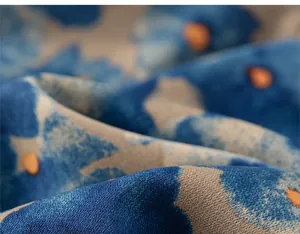 Détail macro de la texture du tissu en sergé doux avec motifs tie-dye bleus et orange