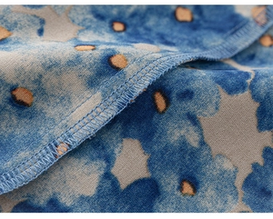 Détail macro d'une couture overlock de qualité sur un tissu tie-dye bleu pour enfants
