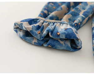 Détail du pantalon enfant style lavis d'encre avec poignets à volants et motif floral abstrait