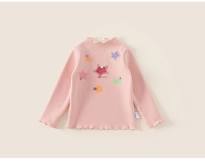 Close-up of pink toddler shirt with star patches, ruffles and decorative buttons