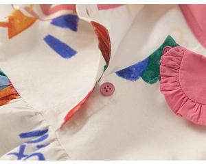Detailed close-up of colorful brushstroke prints and pink ruffle collar on cotton dress
