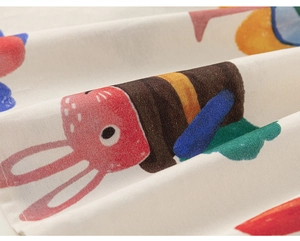 Detailed close-up of cotton fabric with colorful cartoon doodle prints and textile texture