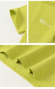Detail of lime green kids t-shirt with insbobo logo and precision stitching at the hem