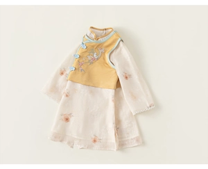 Détail du gilet chinois jaune brodé et de la robe blanche à imprimé floral et dentelle