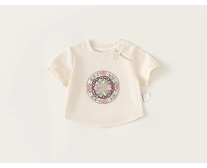Close-up of baby t-shirt featuring Chinese frog button and floral embroidery details