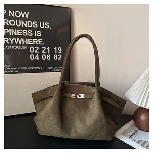 Detail of olive green suede tote bag with golden interlocking metal clasp and soft texture