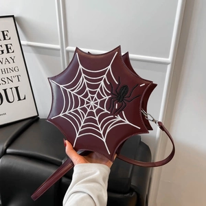 Detail der burgunderroten Handtasche mit Spinnennetz-Stickerei und Spinnenmotiv
