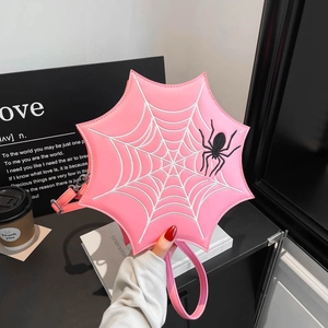Nahaufnahme der rosa Spinnennetz-Handtasche mit feiner Stickerei und verstellbarem Gurt