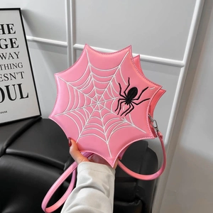 Detail der rosa Spinnennetz-Handtasche mit weißer Stickerei und 3D-Spinne-Akzent