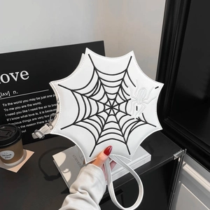 Detail der weißen Spinnennetz-Stickerei und Spinnendekoration auf der Ledertasche