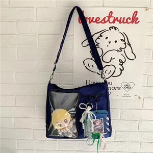 Detail view of navy blue Ita bag with clear PVC window showing a plush toy inside