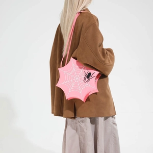 Detail einer pinkfarbenen Spinnennetz-Handtasche mit silbernen Ziernähten