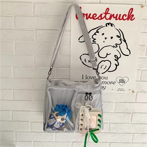 Detail of grey nylon ita bag with a clear window showcasing a cute plush doll