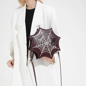 Detail einer Umhängetasche in Spinnennetzform mit 3D-Spinne und verstellbarem Schultergurt