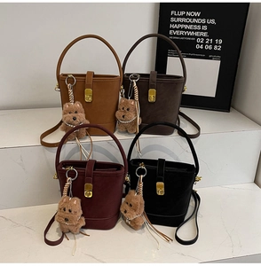 Detailansicht der Eimertaschen in vier Farben mit Plüschanhängern und goldenen Beschlägen