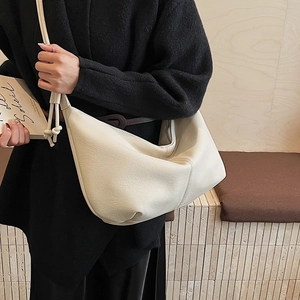 Chic cream-white hobo bag with lychee texture shown on model in a cozy setting
