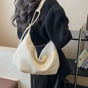 Detailed view of off-white hobo bag with leather texture and knotted shoulder strap detail