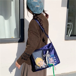 Detail of navy blue Ita bag with transparent window featuring anime accessories