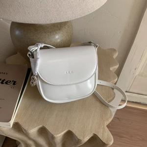 Bolso de montura blanco brillante con colgante de búho plateado y logo grabado