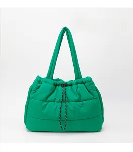 Detail of green quilted puffer tote bag showing water-resistant nylon and drawstring closure