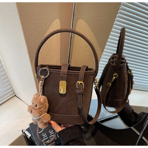 Détails du sac seau vintage en daim marron avec fermoir doré et charm ours en peluche