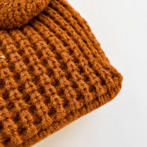 Macro view of caramel brown thick knit fabric with a textured vertical ribbed pattern