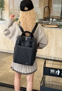 Rear view of model wearing a black business casual backpack with silver rabbit logo detail