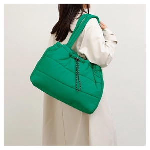 Detail of puffy bright green quilted tote bag with soft padded handle and side drawstring