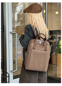 Close-up of woven texture backpack with top leather handles and rabbit metal logo detail