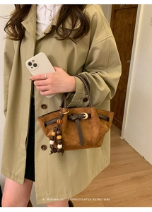 Borsa tote in camoscio marrone con manici in pelle e pendente in perline di legno