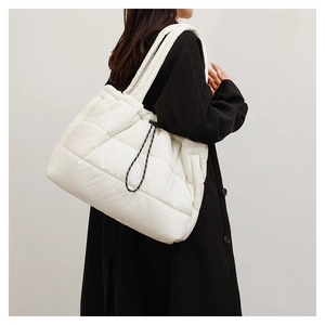 Detail of white puffer tote bag with quilted padding and side woven drawstring detail