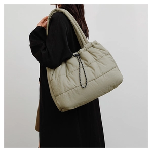 Detail of sage green quilted puffer tote bag with drawstring closure and large capacity