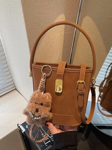 Sac seau élégant en cuir marron avec fermoir doré et joli pendentif en forme de chien