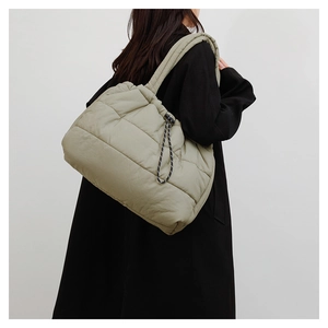 Detail view of the light green quilted tote bag with side drawstring and padded wide strap