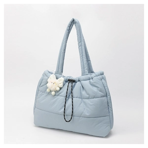 Close-up of quilted down tote bag with drawstring lock and white plush pendant