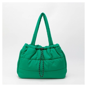 Detail view of bright green quilted tote bag showing plush texture and black drawstring closure
