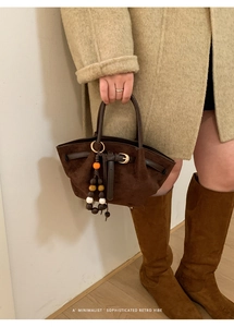 Dettaglio della borsa tote in pelle scamosciata marrone con cinturini in pelle