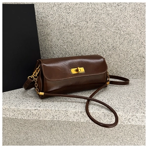 Detailed macro shot of vintage dark brown polished faux leather bag with gold twist lock
