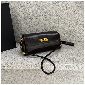 Detail of vintage dark brown faux leather bag featuring a gold rectangular twist-lock