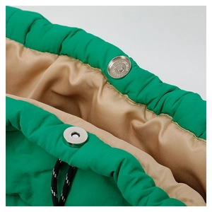 Close-up of green padded tote bag showing silver magnetic closure and drawstrings