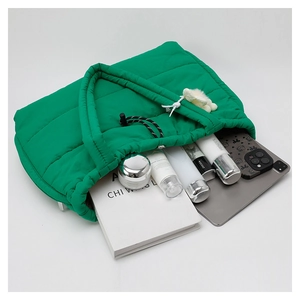 Macro shot of green quilted tote bag interior with storage for books and gadgets