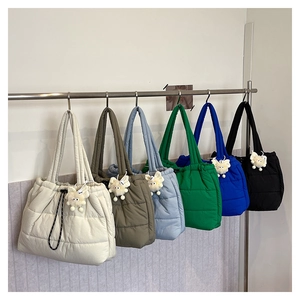 Quilted nylon tote bags in six colors hanging on a rack with plush charm detail