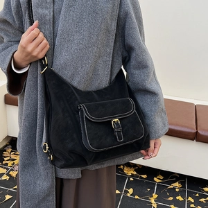 Detail view of black vintage tote bag with white contrast stitching and golden buckle