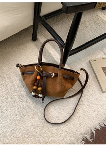 Dettaglio della borsa tote in pelle scamosciata marrone con ciondolo di perline