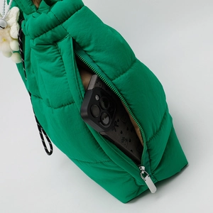 Bright green quilted puffer tote bag with side zipper pocket and floral pendant detail