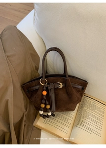 Vista dettagliata della borsa tote in pelle scamosciata marrone scuro con manici in pelle
