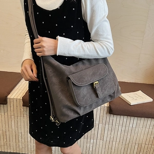 Detail of dark grey tote bag with contrast white stitching and gold metal buckle pocket